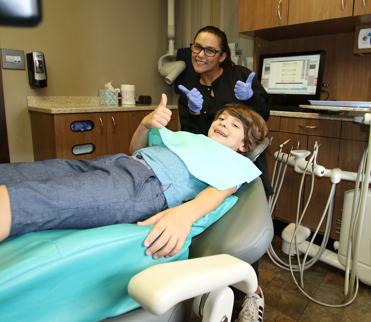 Kid giving thumbs up after a dental exam at Grins & Giggles Family Dentistry in Spokane Valley, WA