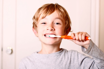 Boy demonstrating good oral hygiene and brushing his teeth at Grins and Giggles Family Dentistry in Spokane Valley, WA