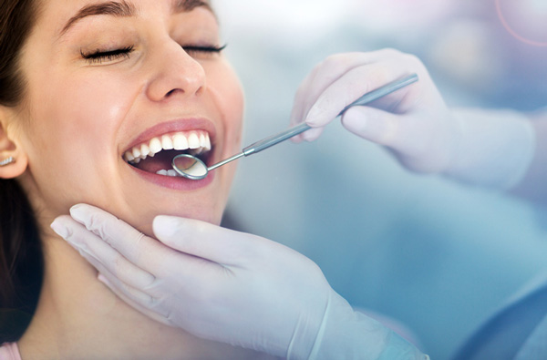 Woman getting a dental exam at Grins & Giggles Family Dentistry in Spokane Valley, WA