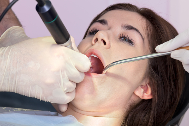 Woman getting a dental cleaning at Grins & Giggles Family Dentistry in Spokane Valley, WA